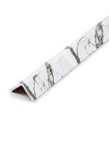 L-shaped acoustic and fluted wall panel trim with a white marble-look finish and gray veining