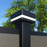 Black LED cap installed on a composite fence post in daylight with leafy trees behind