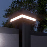 LED cap glowing on a black composite fence post at night beneath trees