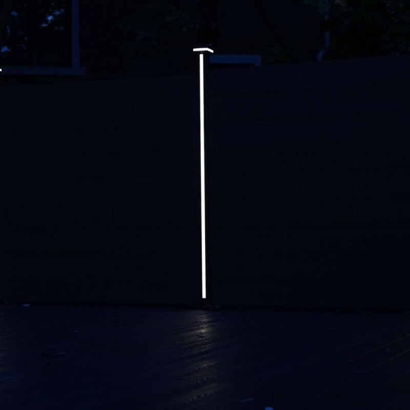 LED strip glowing vertically on a composite fence post at night