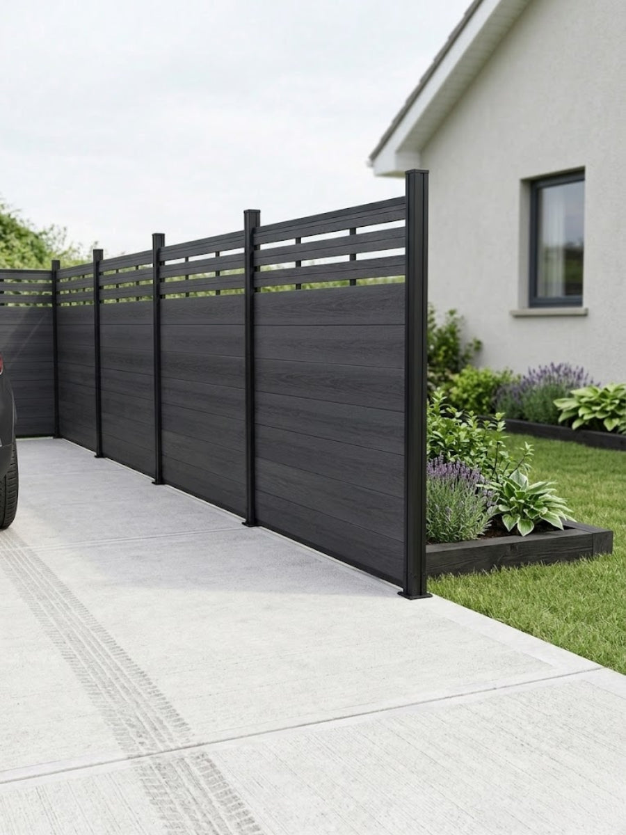 Black composite privacy fence with horizontal lattice top installed beside a driveway and garden