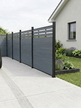 Light gray top lattice composite privacy fence installed beside a concrete driveway and garden