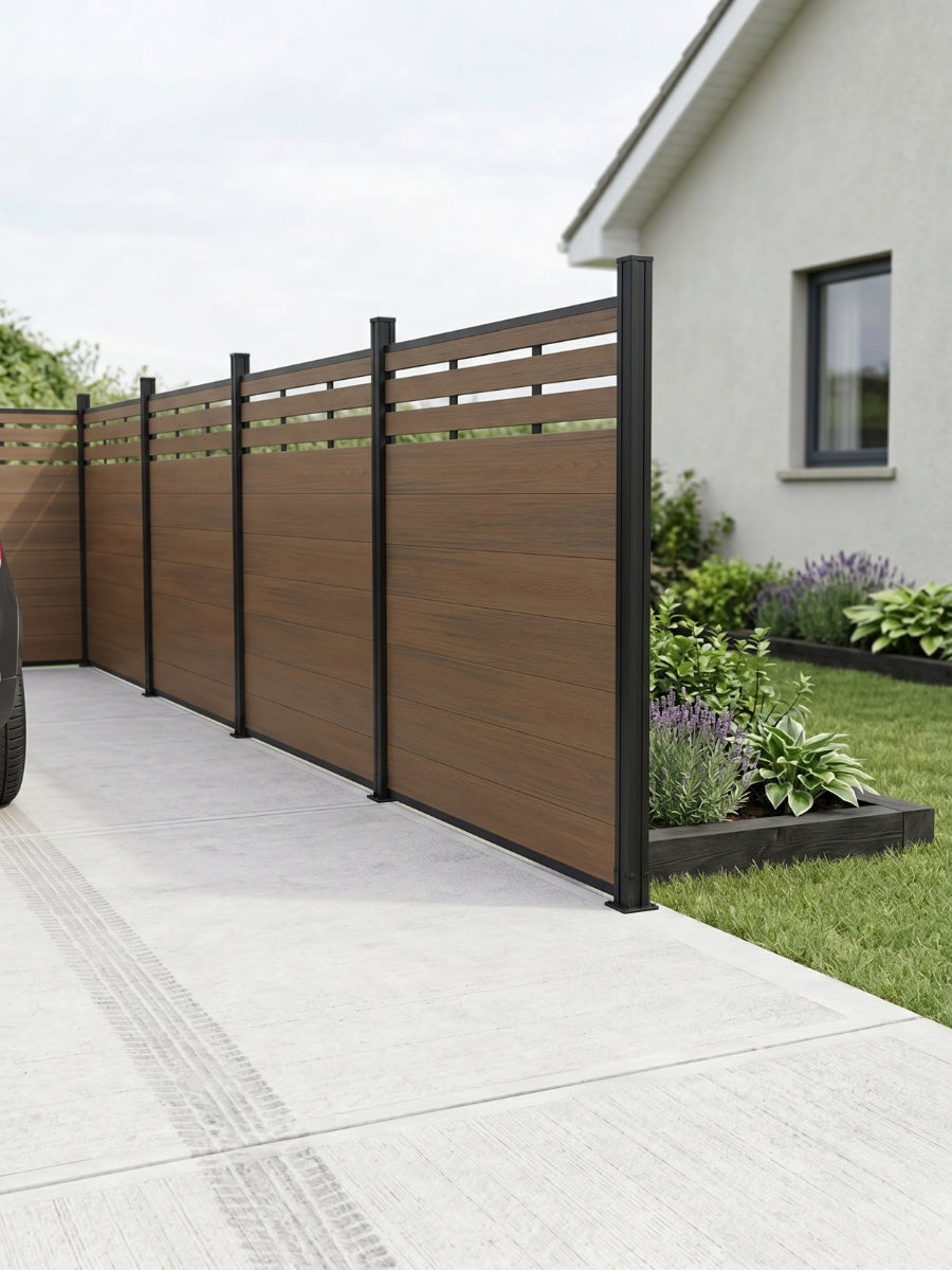 Walnut lattice-top composite privacy fence installed along a concrete driveway and garden bed