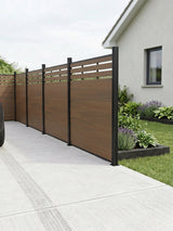 Walnut lattice-top composite privacy fence installed along a concrete driveway and garden bed