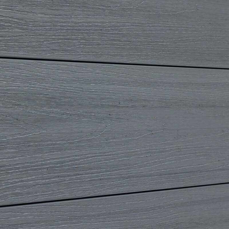 Detailed view of light gray composite fence boards with subtle wood-grain texture