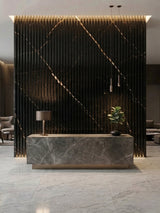 Noir Royale fluted wall panels forming a black and gold-toned backdrop for a reception desk