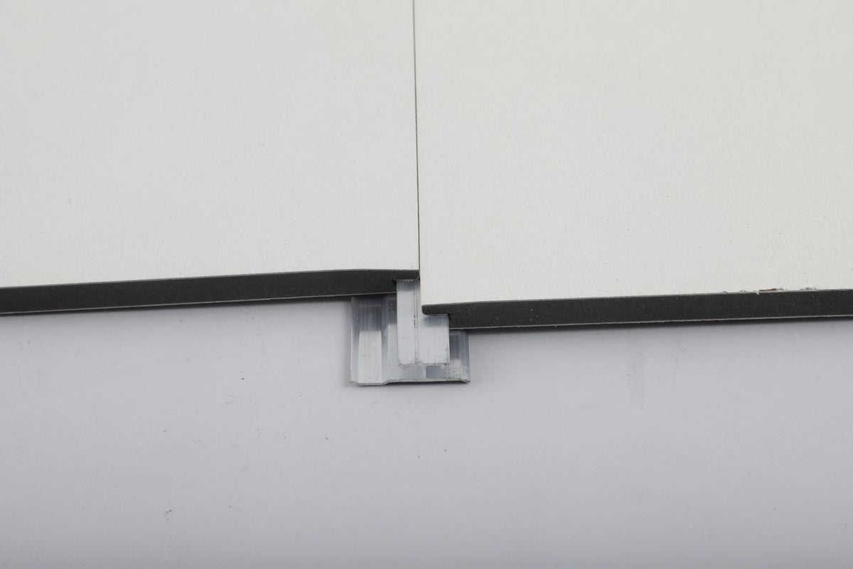 Aluminum invisible seamless trim connector fitted beneath the joint of two white panels