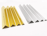 Gold and silver V-shaped aluminum wall panel trims arranged on a white background
