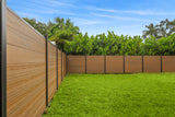 Walnut composite privacy fence with black posts enclosing a green lawn