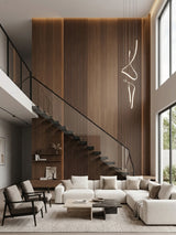 Walnut wood veneer panels with vertical slats covering a double-height living room wall behind a modern staircase