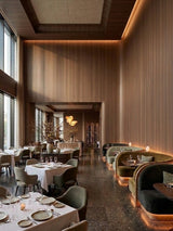 Walnut wood veneer panels lining a softly lit upscale restaurant dining room