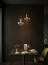 Walnut Ink Metallic 3D fluted wall panels installed behind an intimate dining table with pendant lights