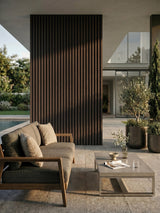Dark brown and black composite cladding installed as a vertical accent wall on a covered patio