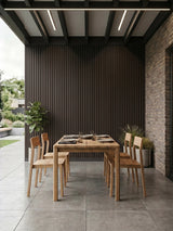 Covered outdoor dining area with dark brown and black composite cladding on the back wall