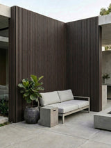 Courtyard seating area enclosed by dark brown and black composite vertical cladding walls