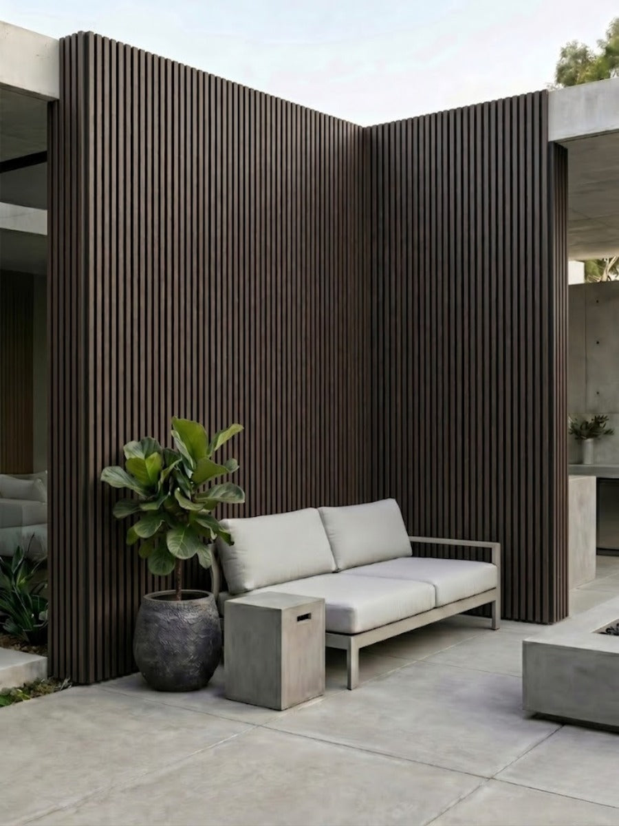 Courtyard seating area enclosed by dark brown and black composite vertical cladding walls