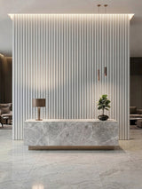 White brushed WPC fluted 3D wall panels installed behind a marble-look reception desk