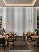 Floor-to-ceiling white brushed WPC fluted wall panels on a backlit restaurant feature wall