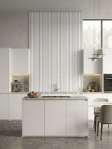 White fluted 3D wall panels forming a tall accent wall behind a modern kitchen island