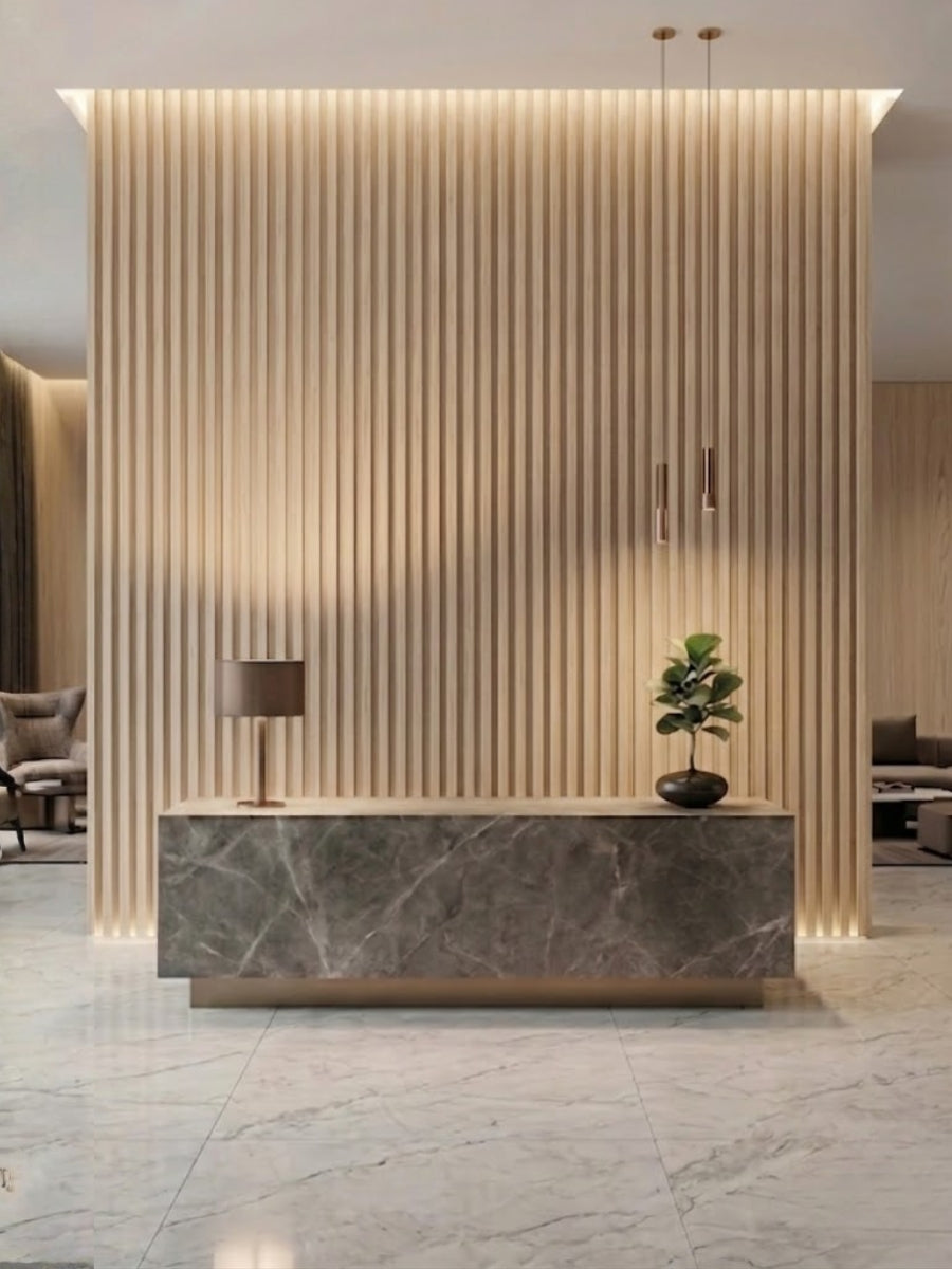 White oak WPC fluted wall panels forming a backlit feature wall behind a stone reception desk