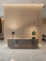White oak WPC fluted wall panels forming a backlit feature wall behind a stone reception desk