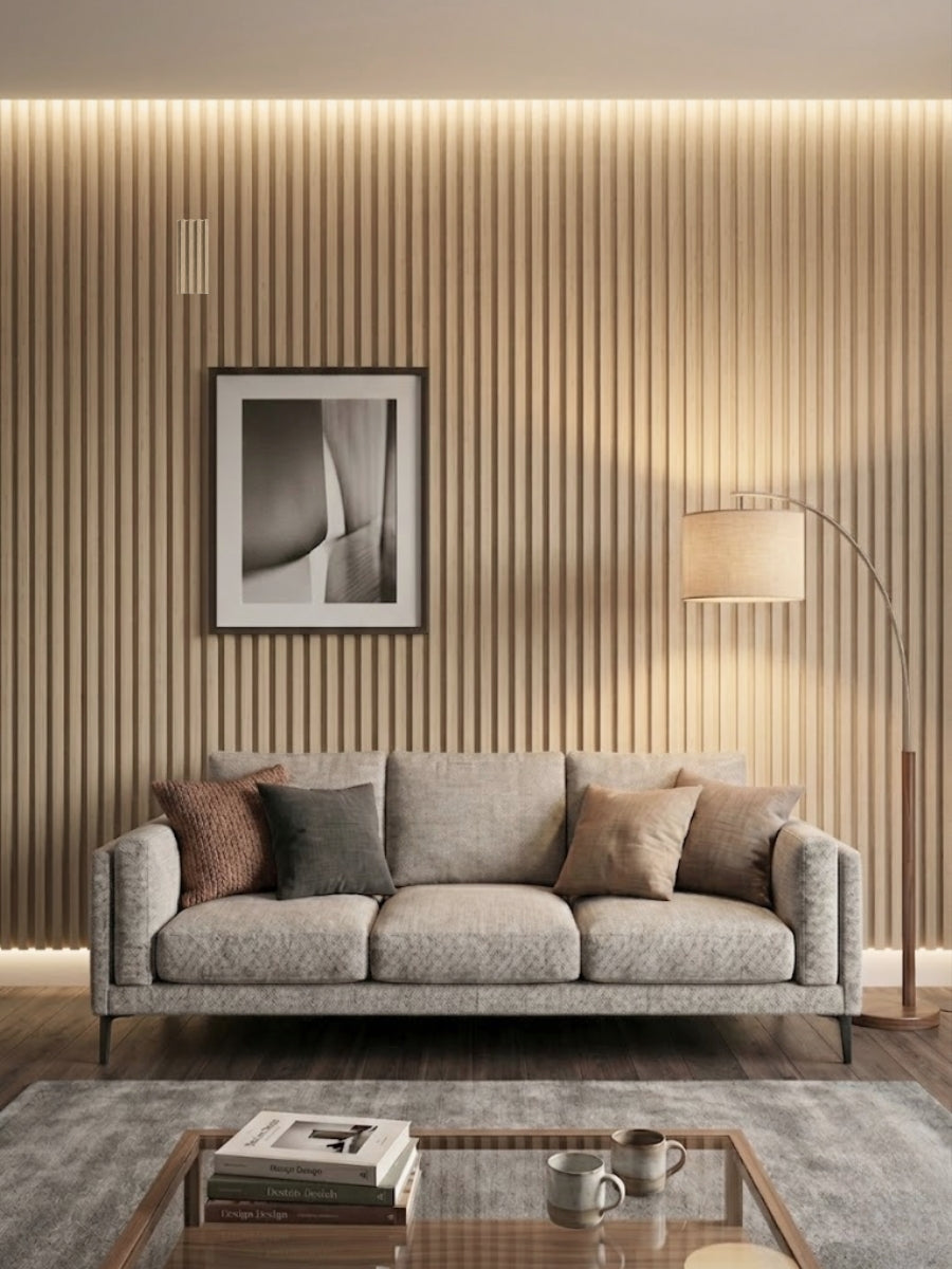 White oak WPC fluted 3D wall panels installed behind a gray living room sofa