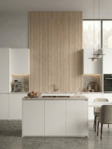 White oak WPC fluted wall panels creating a tall kitchen accent wall above the island