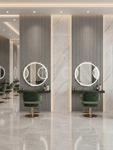 White linen fluted wall panels framing illuminated round mirrors and green salon chairs