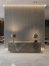 White linen WPC fluted 3D panels installed as a floor-to-ceiling reception desk backdrop