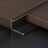 Black Z-shaped aluminum wall panel trim sample installed between wood-look panels
