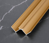 Gold 3mm aluminum inside corner trim profile close-up on dark marble