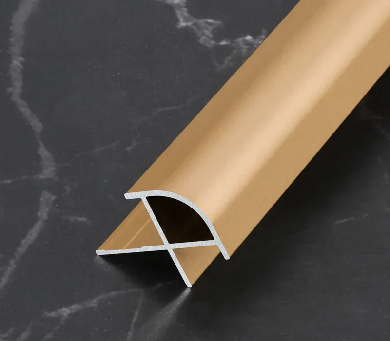 Gold curved aluminum wall panel trim sample with its cross-section visible