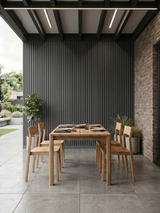 Gray composite wide exterior cladding installed as a vertical accent wall in a covered outdoor dining area