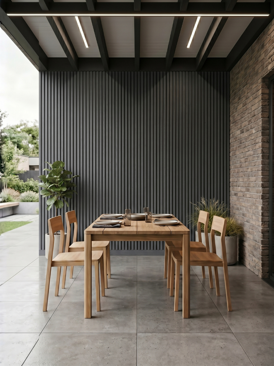 Gray composite wide exterior cladding installed as a vertical accent wall in a covered outdoor dining area