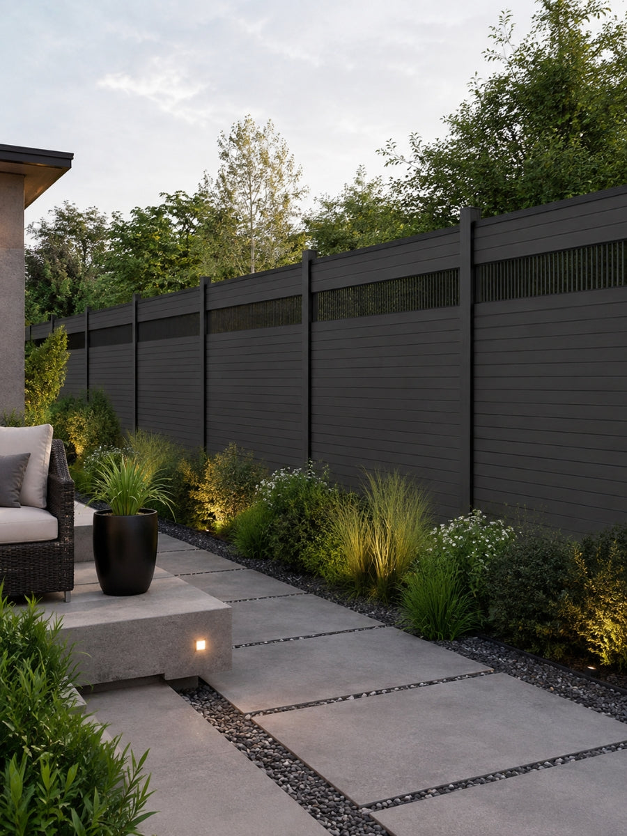 Modern decorative fence screens with narrow vertical slats installed along a dark fence beside a landscaped walkway