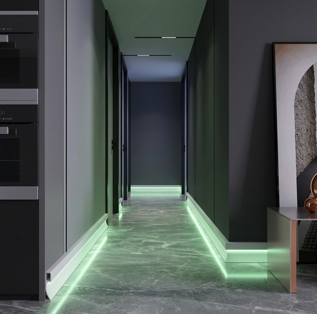 White LED baseboard molding installed along a dark hallway with soft green floor lighting