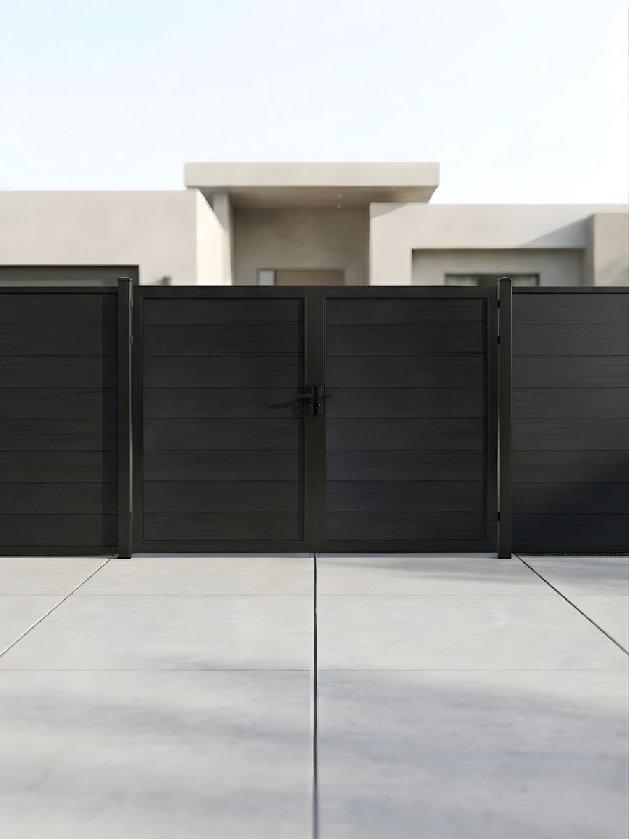 Closed black WPC double fence gate installed across a modern paved entrance