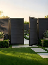 Black WPC double fence gate partially open in a landscaped garden setting