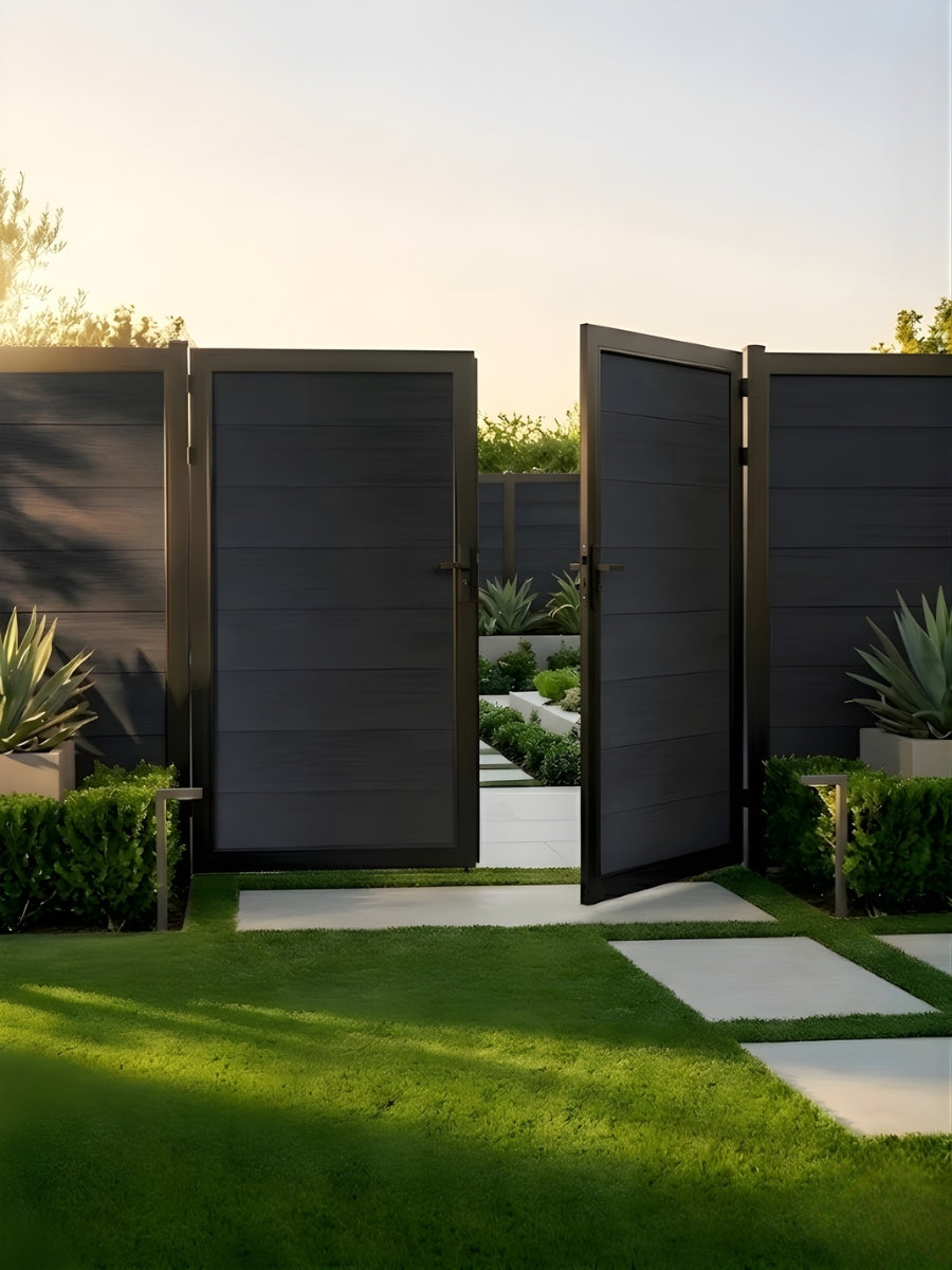 Black WPC double fence gate partially open in a landscaped garden setting