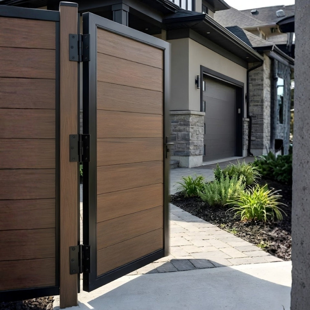 Open brown WPC fence gate showing black hinges beside a landscaped residential walkway