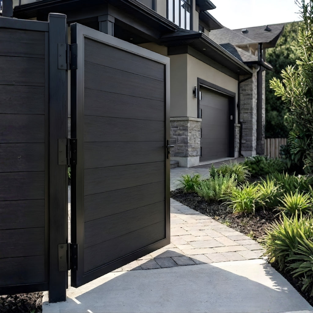 Open black WPC fence single gate leading to a landscaped home walkway