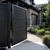 Open black WPC fence single gate leading to a landscaped home walkway