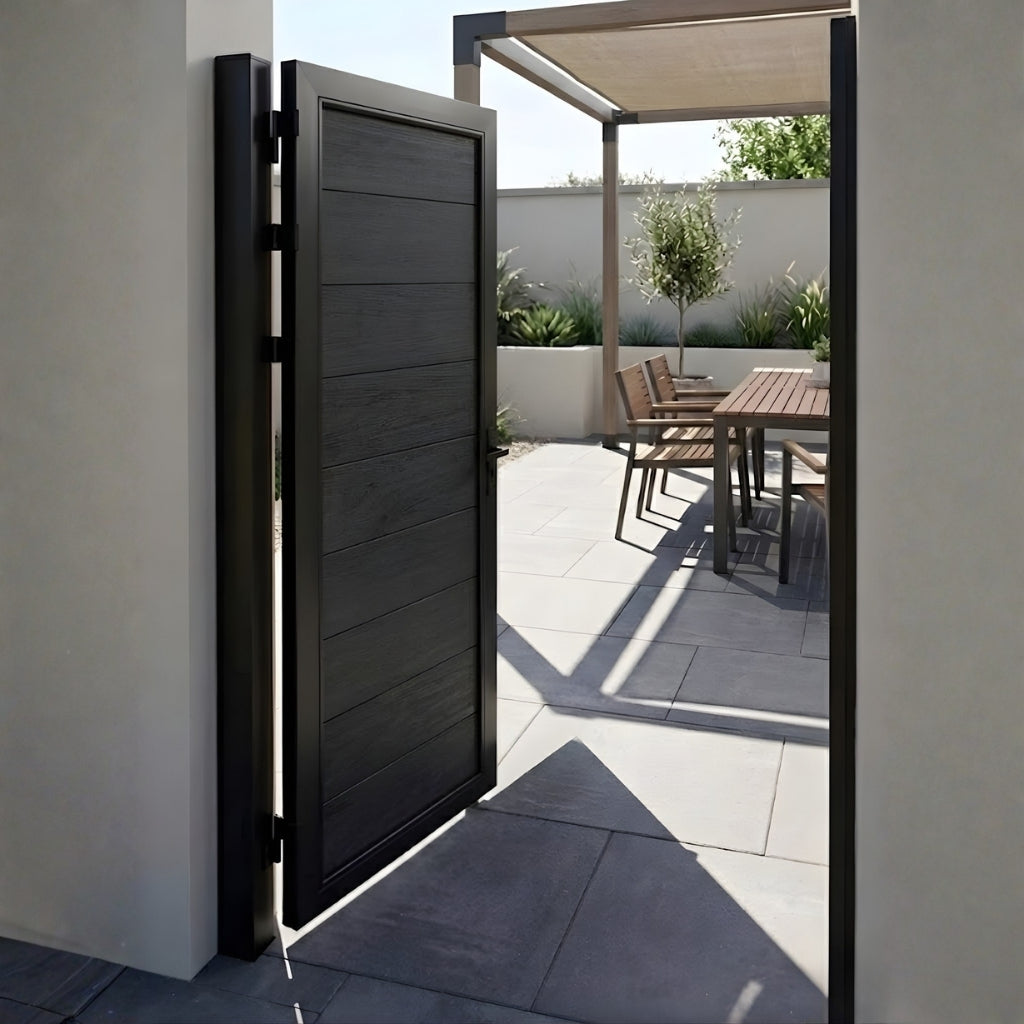 Open black WPC fence single gate at the entrance to a contemporary patio dining area