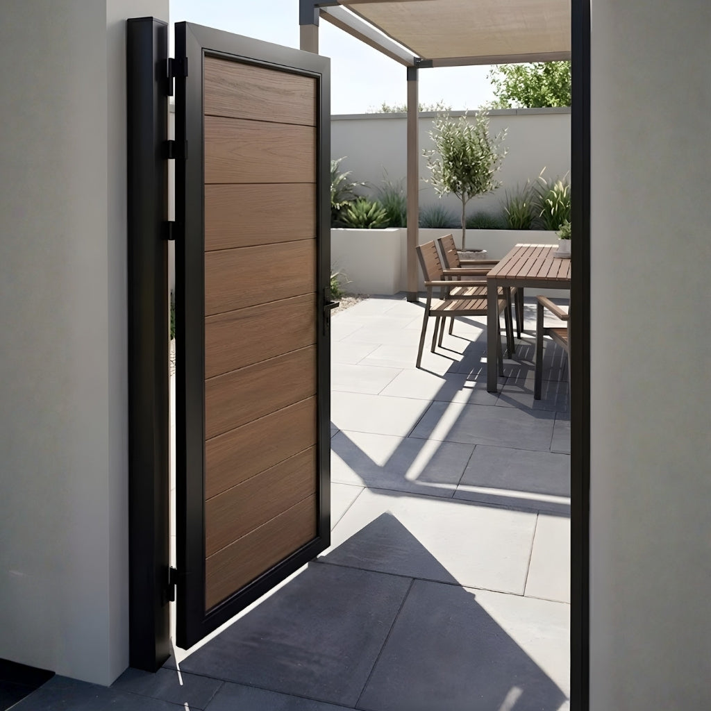 Open brown WPC fence single gate leading to a sunlit patio dining area